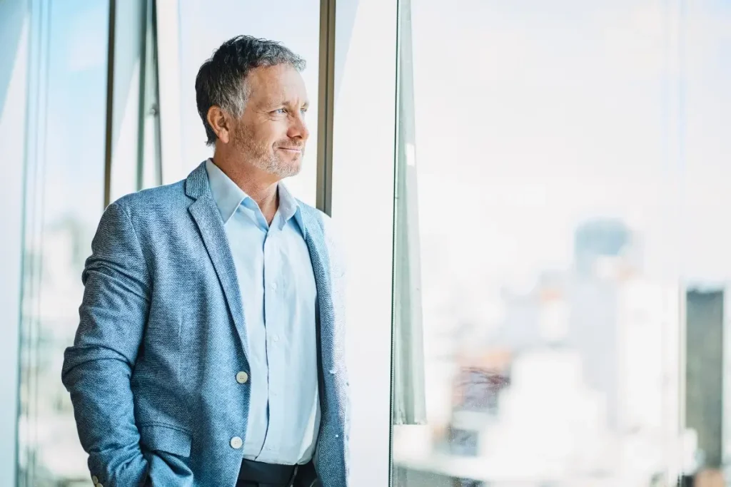 Confident male financial advisor looking out of a window.