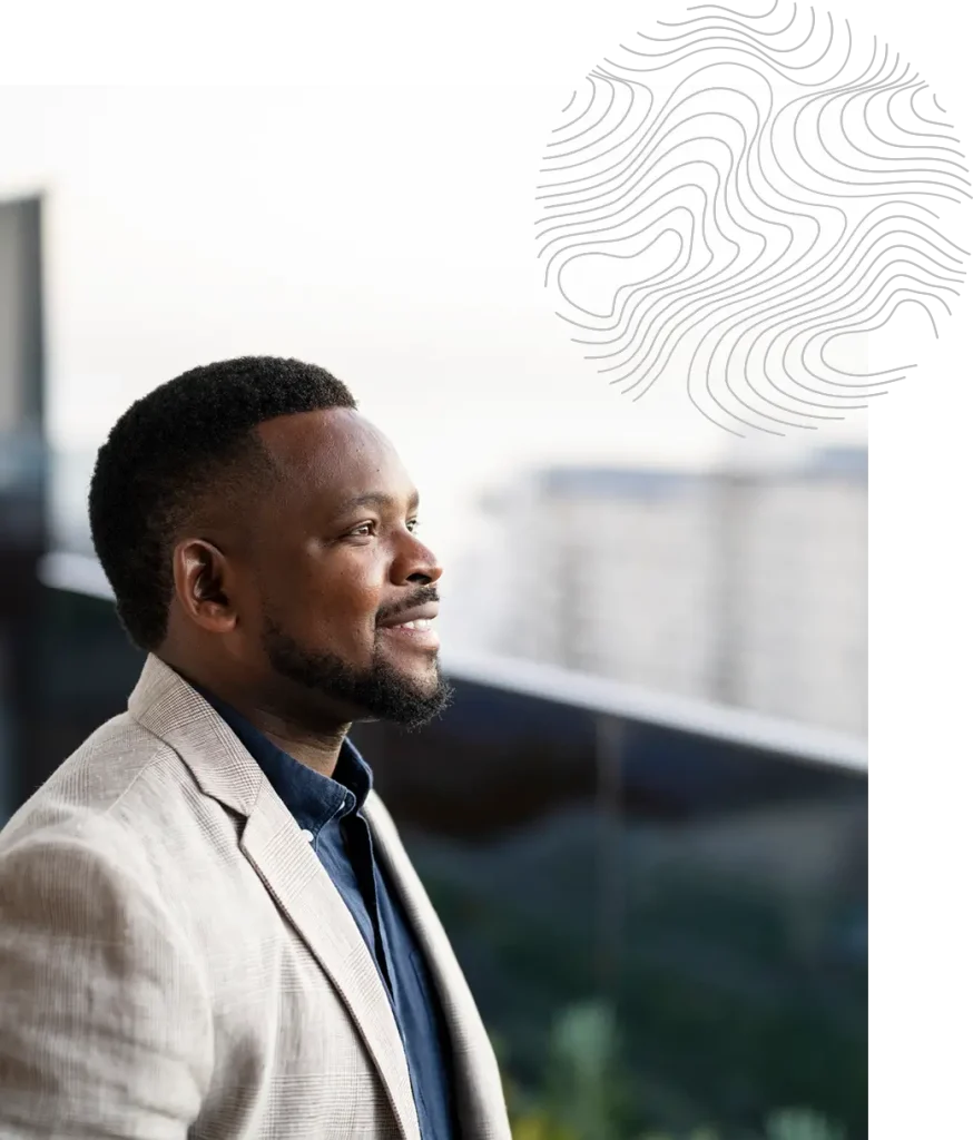 Happy financial advisor in a blazer looking out a window.