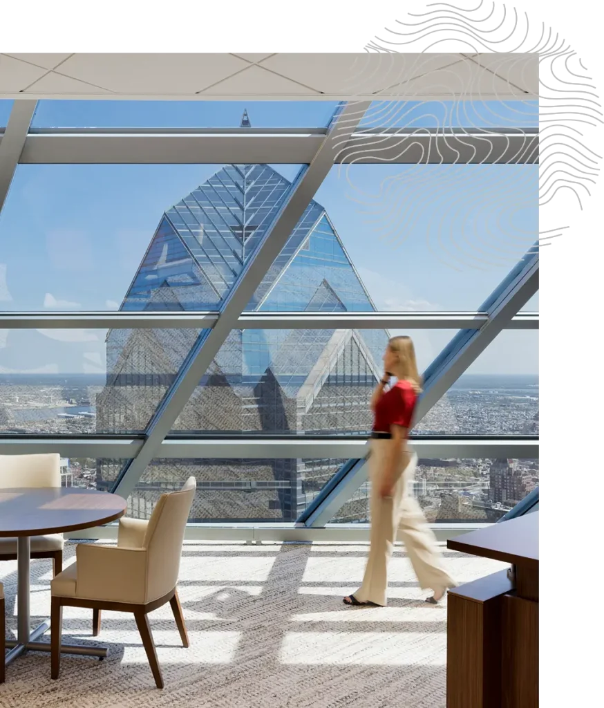 Financial advisor in a modern office with large glass windows and a view of a city skyline.